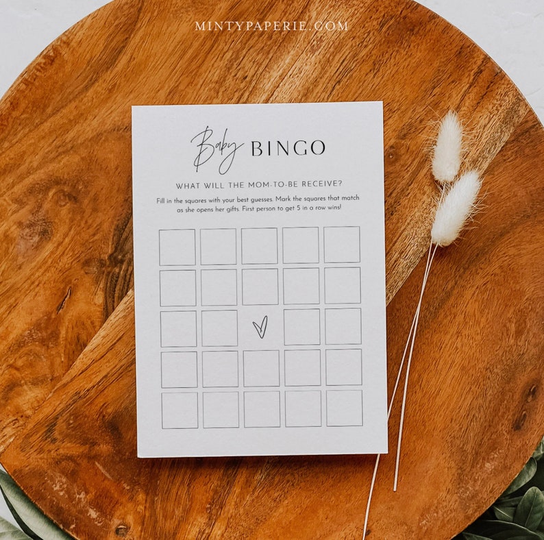 May include: A printable baby shower bingo card with the title "Baby Bingo" and the instructions "What will the mom-to-be receive? Fill in the squares with your best guesses. Mark the squares that match as she opens her gifts. First person to get 5 in a row wins!"