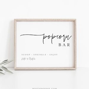 May include: A printable sign for a popcorn bar with the text "popcorn bar" in a script font. The sign also includes the text "Scoop. Sprinkle. Enjoy" and the names "Katie & Martin".