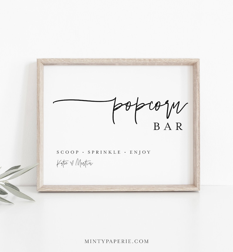 May include: A printable sign for a popcorn bar with the text "popcorn bar" in a script font. The sign also includes the text "Scoop. Sprinkle. Enjoy" and the names "Katie & Martin".