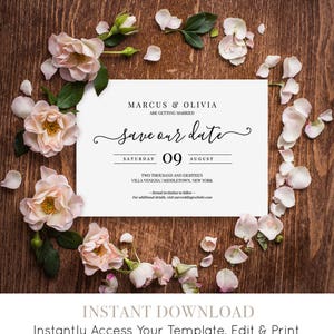 K&ouml;nnte beinhalten: Eine Save-the-Date-Karte mit wei&szlig;em Hintergrund und schwarzem Text. Die Karte zeigt die Namen Marcus und Olivia, das Datum Samstag, 09. August, und den Ort Villa Venezia, Middletown, New York. Die Karte ist von rosa Rosenbl&auml;ttern auf einem Holzgrund umgeben.