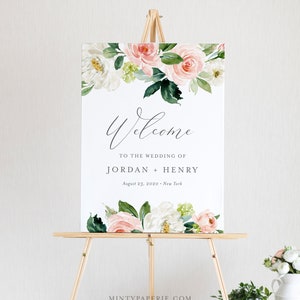 May include: A wedding welcome sign with a floral design featuring pink and white flowers. The sign reads "Welcome to the wedding of Jordan + Henry, August 23, 2020, New York".