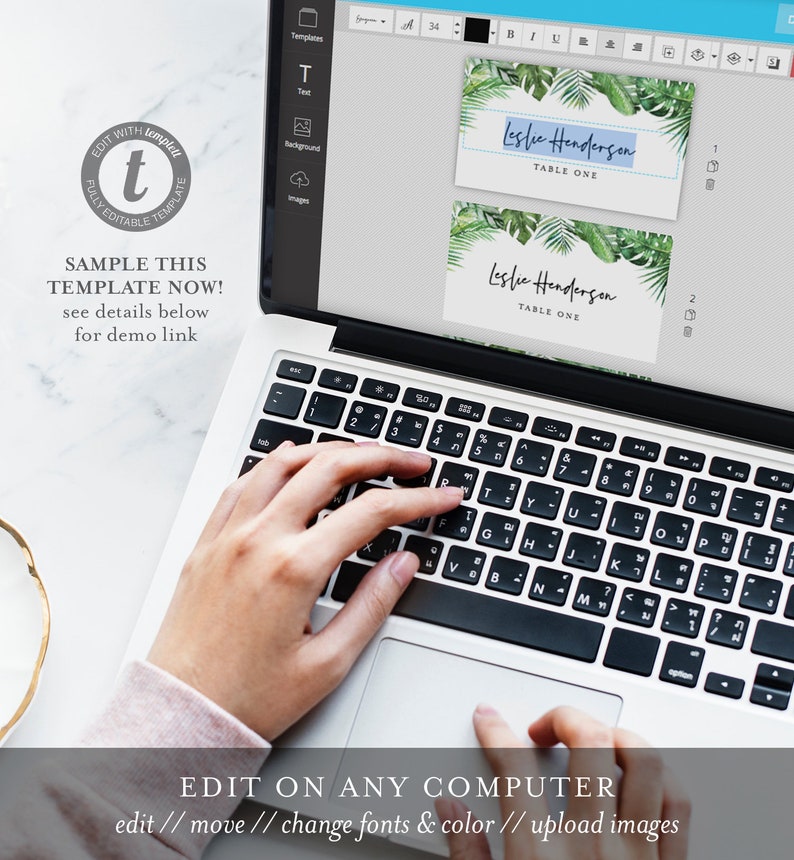 May include: A laptop computer screen displaying a template for a table card with the text "Leslie Henderson, Table One". The template has a tropical leaf design. A hand is typing on the keyboard.