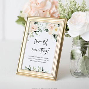 May include: A gold-framed sign with a floral design and the text "How old were they?"  Guess how old the bride and groom were in each photo. Person with the most correct answers wins!