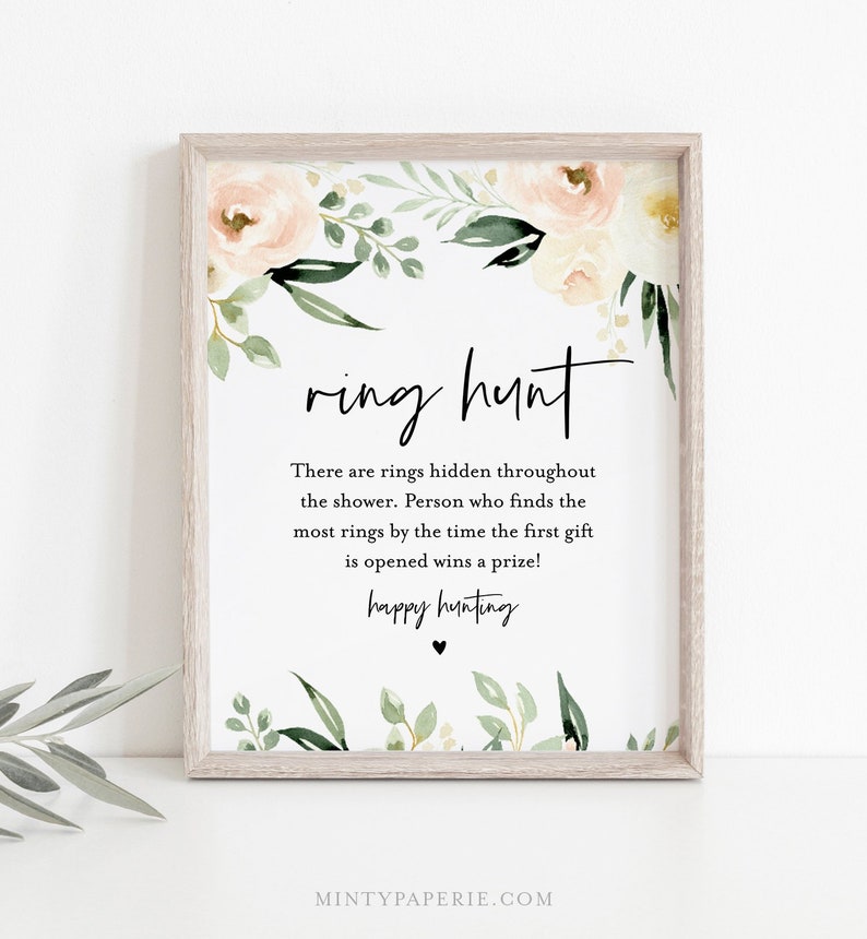 Pu&ograve; includere: Un cartello stampabile con un bordo floreale e il testo "ring hunt". Il cartello dice "There are rings hidden throughout the shower. Person who finds the most rings by the time the first gift is opened wins a prize! happy hunting".