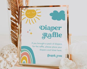 May include: A gold-framed sign with a blue and yellow rainbow, a sun, and a cloud. The sign says "Diaper Raffle" and "If you brought a pack of diapers for the raffle, please place your diapers and ticket here. Thank you."