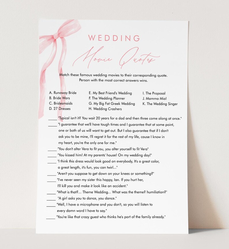 May include: A wedding game card with the title "Wedding Movie Quotes" in a delicate script font. The card features a pink ribbon and a list of movie titles and quotes for guests to match. The design is simple and elegant, perfect for a bridal shower.