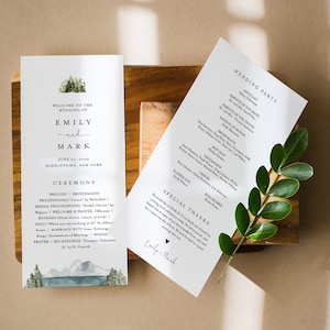 Puede incluir: Programa de ceremonia de boda con una ilustración de acuarela de un bosque y un lago. El programa enumera la fiesta de bodas, los detalles de la ceremonia y un mensaje especial de agradecimiento de la pareja, Emily y Mark.