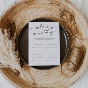 Puede incluir: Una tarjeta de juego de boda imprimible con el texto "d&oacute;nde estaban" en una fuente manuscrita. La tarjeta tiene un espacio en blanco para 12 fotos y pide a los invitados que adivinen d&oacute;nde estaban la novia y el novio en cada foto.
