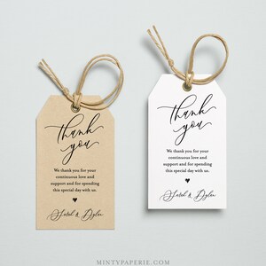 May include: Two wedding favor tags with a brown and white background. The text on the tags reads "Thank you" in a cursive font. The text continues with "We thank you for your continuous love and support and for spending this special day with us." The tags are signed with "Sarah & Dylan".
