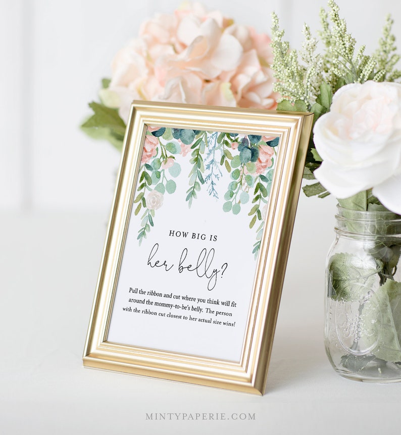 May include: A white card with a floral design in shades of pink, green, and blue. The card has the text "HOW BIG IS her belly?" and instructions for a baby shower game.
