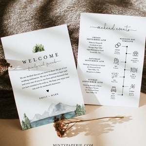 May include: A wedding invitation suite with a watercolor illustration of mountains and a forest. The invitation includes the text "Welcome family and friends" and the names "Emily & Mark". The back of the invitation includes a timeline of wedding events.