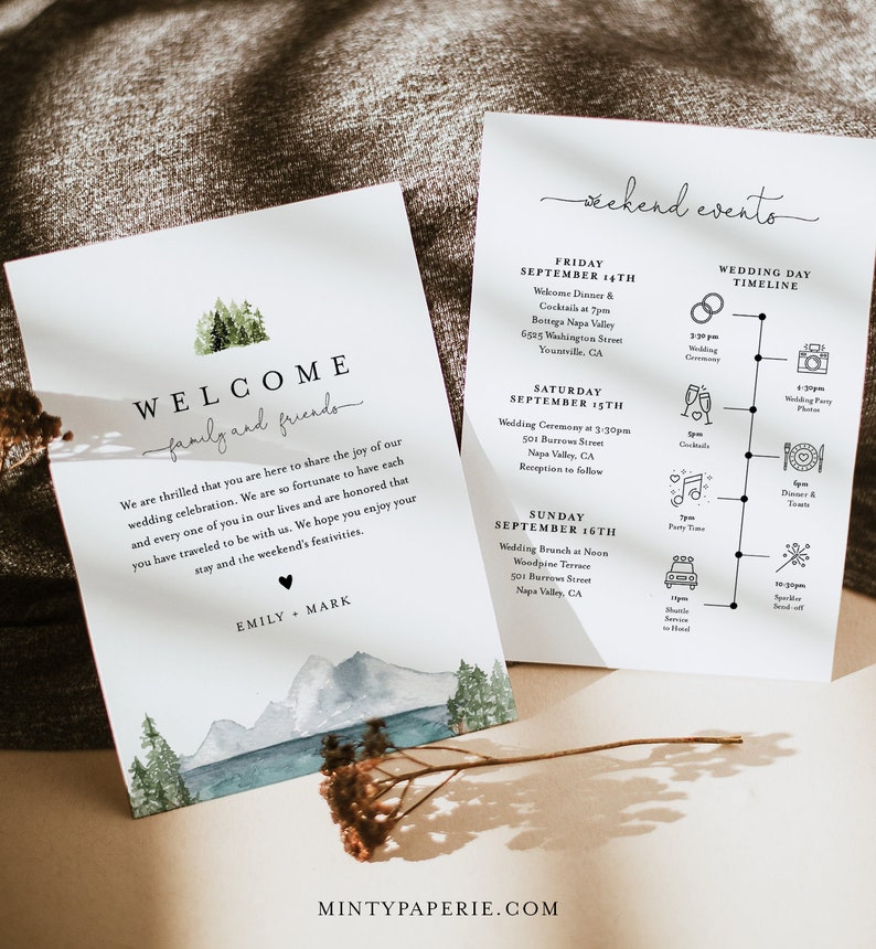 May include: A wedding invitation suite with a watercolor illustration of mountains and a forest. The invitation includes the text "Welcome family and friends" and the names "Emily & Mark". The back of the invitation includes a timeline of wedding events.