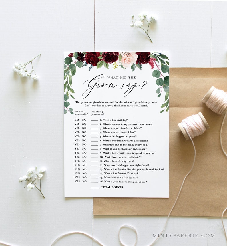 May include: A printable bridal shower game with a floral design in shades of burgundy and pink. The game is called "What Did the Groom Say?" and asks the bride to guess the groom's answers to 16 questions about her.