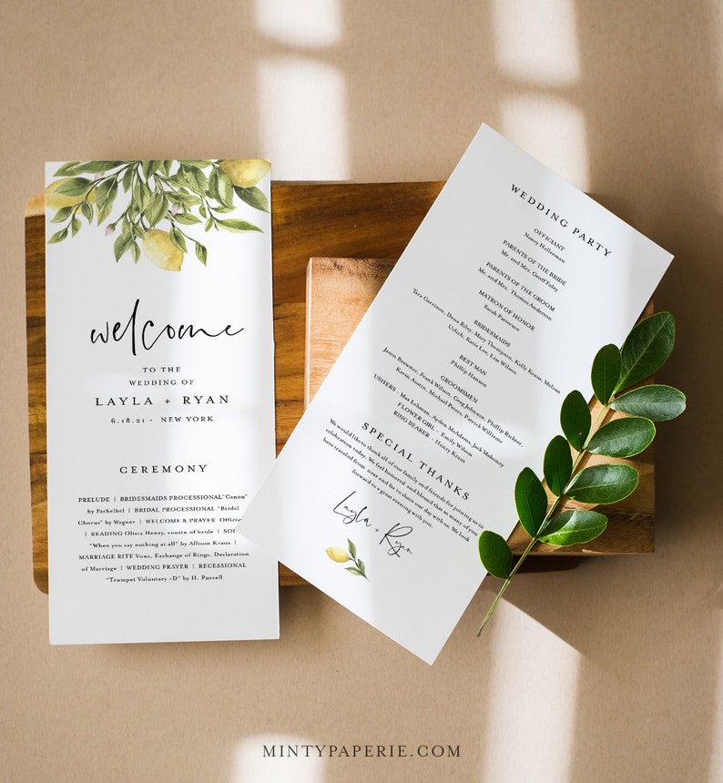 May include: A wedding ceremony program with a lemon and green foliage design. The program includes the wedding party, ceremony details, and a special thanks section. The text reads "Welcome to the wedding of Layla & Ryan 6.18.21 New York".