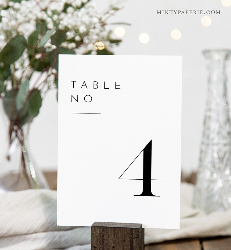 May include: White table number card with black text that reads "Table No. 4".