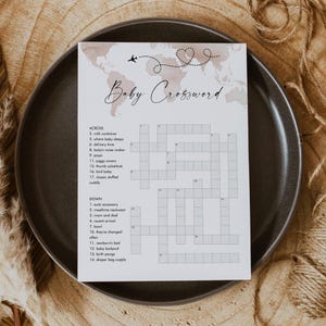 May include: A printable baby shower game in the form of a crossword puzzle. The crossword puzzle is on a white background with a brown watercolor world map design. The crossword puzzle has the title "Baby Crossword" and includes clues for words related to babies and new parents.