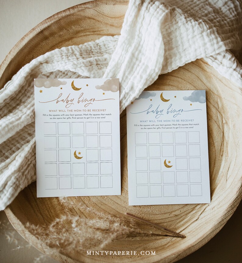 May include: Two blue and gold baby shower bingo cards with a crescent moon and stars design. The text on the cards reads "Baby Bingo" and "What will the mom-to-be receive?"