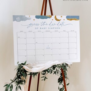 May include: A blue and gold baby shower game with a calendar to guess the due date of Baby Simpson. The calendar has a blue star marking the due date.