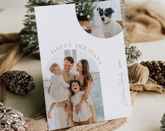 May include: A holiday greeting card with a family photo and a photo of a dog. The card has the words "Happy Holidays" in gold script. The family photo shows a family of four. The dog is black and white.