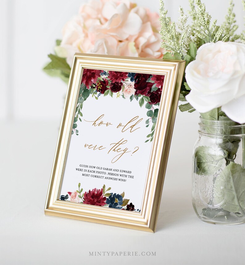 May include: A printable wedding game card with a floral design in shades of burgundy, pink, and blue. The text reads "How old were they?" and "Guess how old Sarah and Edward were in each photo. Person with the most correct answers wins!"