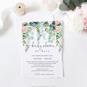 May include: Baby shower invitation with watercolor floral design in pink, green, and blue. The invitation reads "baby shower by mail" and includes details for gift mailing. The paper has a torn edge.