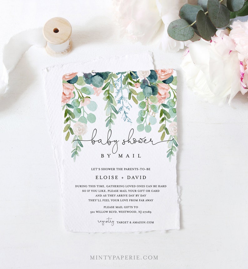 May include: Baby shower invitation with watercolor floral design in pink, green, and blue. The invitation reads "baby shower by mail" and includes details for gift mailing. The paper has a torn edge.