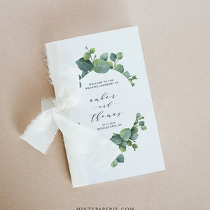 Könnte beinhalten: Ein weißes Hochzeitsprogramm mit einem grünen Eukalyptus-Kranz-Design. Der Text lautet "Willkommen zur Trauung von Amber und Thomas 06.23.2019 Middletown, NY".