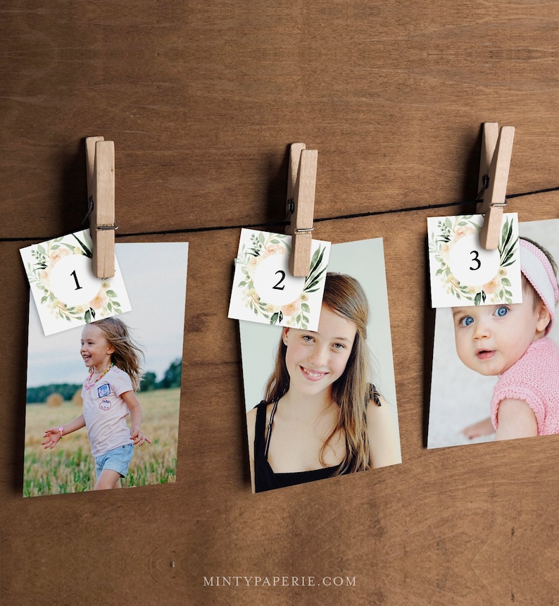 May include: Three photos are displayed on a wooden background. Each photo is held by a clothespin and has a floral wreath with a number in the center. The numbers are 1, 2, and 3. The photos show a young girl running, a teenage girl smiling, and a baby looking at the camera.