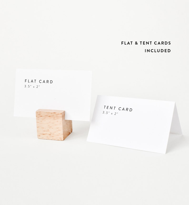 May include: Two blank white cards, one flat and one folded into a tent shape, with the dimensions 3.5 inches by 2 inches printed on each. The cards are displayed on a white surface with a small wooden block holding the flat card.