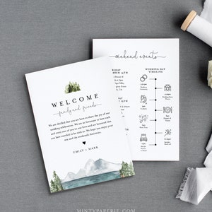 May include: A welcome sign with a watercolor illustration of mountains, trees, and a lake. The text reads "Welcome family and friends" and "Emily + Mark". The sign also includes a wedding day timeline with icons for the ceremony, cocktails, party time, dinner and toasts, and sparkler send-off.