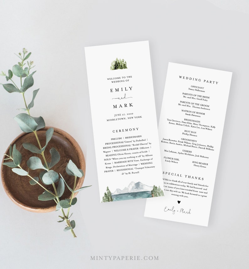 May include: Wedding ceremony program with a watercolor illustration of mountains and a lake. The program includes the names Emily and Mark, the date June 27, 2020, and the location Middletown, New York. The program also includes a list of the wedding party members and their roles.