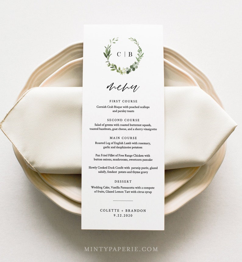 May include: A wedding menu card with a floral wreath and the initials "C B" at the top. The menu lists a three-course meal with dessert. The card is on a white napkin and a beige plate. The date is 9.22.2020.