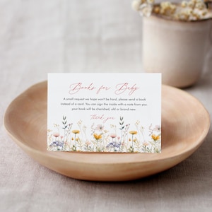 Puede incluir: Una tarjeta blanca con un borde floral y el texto "Books for Baby". El texto dice: "Una pequeña petición que esperamos no sea difícil, por favor envía un libro en lugar de una tarjeta. Puedes firmar el interior con una nota de tu parte. Tu libro será apreciado, viejo o nuevo. Gracias."