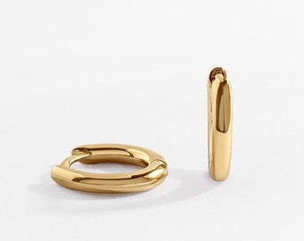 May include: A pair of gold hoop earrings. The earrings are simple and elegant, with a smooth, polished finish.