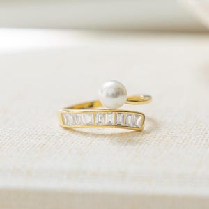 Freshwater pearl ring intertwined with gold baguette wrap ring