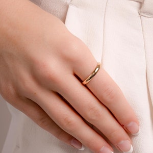 a model's hands showcasing a minimalist gold band measuring 3mm