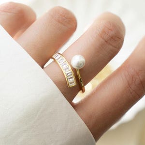 model wearing gold baguette ring featuring a spiral ring design and a freshwater pearl