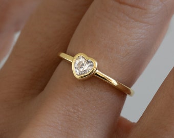 May include: A gold ring with a clear heart-shaped stone.