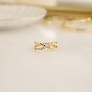 close up of gold wedding band with an X design