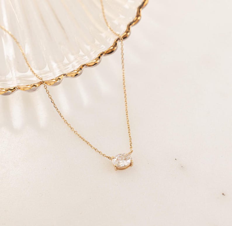 Closeup image of oval cut diamond necklace in gold