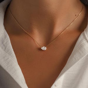 Gold dainty teardrop necklace on model