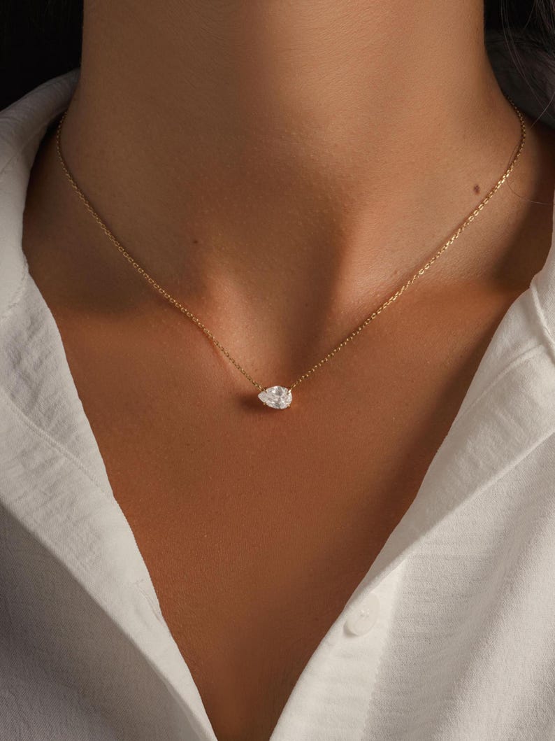 Gold dainty teardrop necklace on model