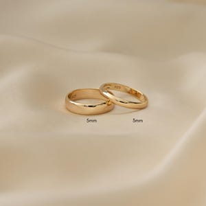 an image showing two dainty gold rings, they are plain bands in two sizes, 5mm and 3mm