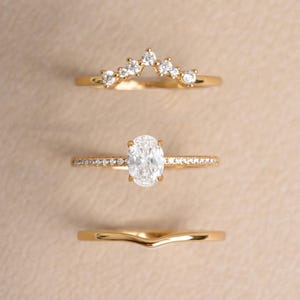 Gold dainty stackable oval ring set on a beige background