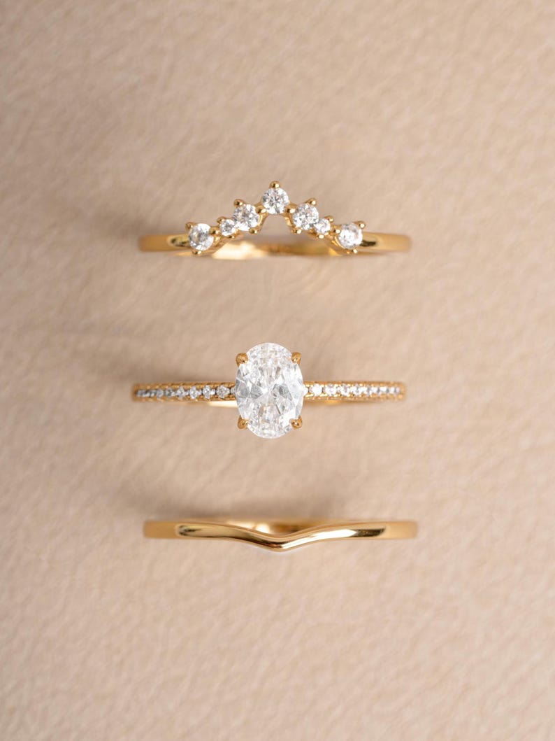 Gold dainty stackable oval ring set on a beige background