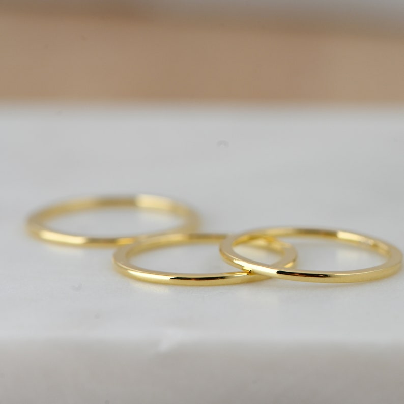 May include: Three gold stacking rings, each with a simple, polished finish.