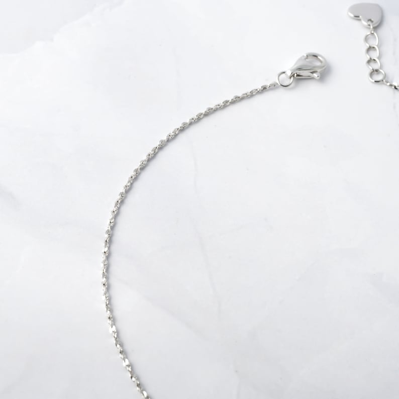 May include: A silver chain necklace with a heart-shaped clasp.