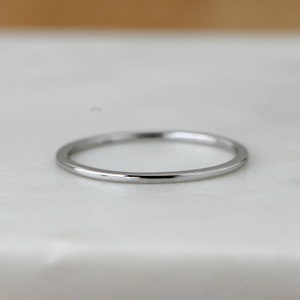 May include: A simple silver band ring with a polished finish.