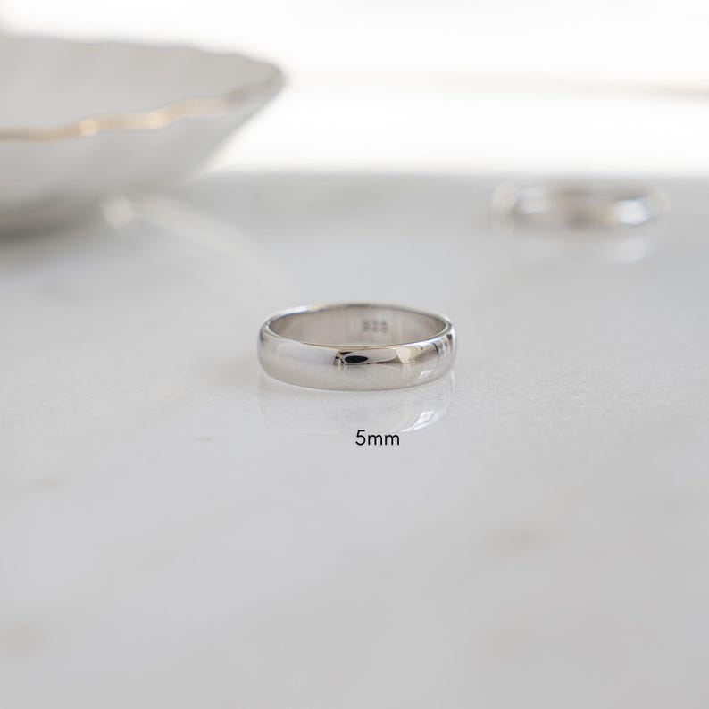 a close up of a minimalist sterling silver wedding band