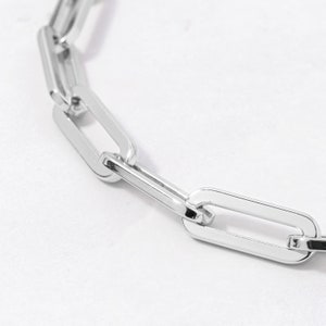 May include: A silver chain necklace with large, oval-shaped links.